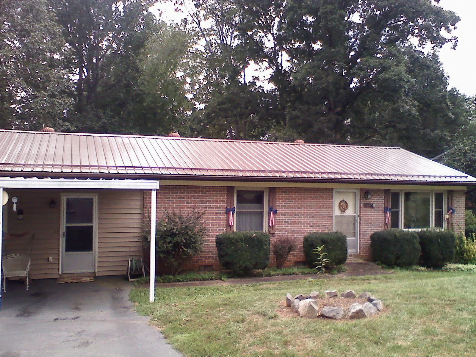 Bronze metal roof and carport on a brick ranch home — Roof Repair work by our crew in Weirsdale